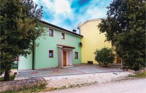 dom z zieloną i żółtą fasadą w obiekcie Holiday Home Betiga With Sea View Vi w mieście Barbariga