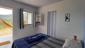 Un dormitorio con una cama con sábanas azules y una ventana. en Chalés Canto da Graúna, en Ibicoara