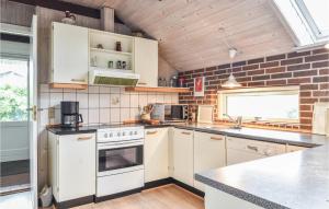 a kitchen with white appliances and a brick wall at Holiday Home P Snejkers Vej Ringkøbing I in Søndervig