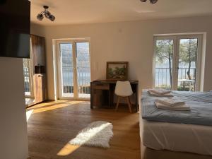una camera da letto con un letto e una scrivania con una sedia di Lakesideview Keutschach am See a Keutschach am See