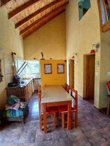 Una cocina con una mesa y sillas en una habitación. en El Jardin de Sauce, en Monte Hermoso