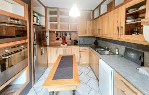 eine Küche mit Holzschränken und einer hölzernen Arbeitsplatte in der Unterkunft Stunning Home In Grand-Fort-Philippe in Grand-Fort-Philippe + 14 Fotos