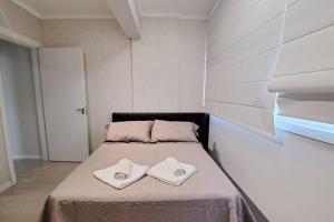 a bed with two white towels on top of it at Apartamento aconchegante próximo Maria Fumaça in Bento Gonçalves