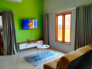 a green living room with a couch and a table at 3 Bedroom Fully Furnished LC Home in Singaraja