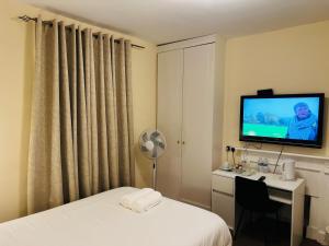 a hotel room with a bed and a desk and a television at Vauxhall Stay in London +12 photos
