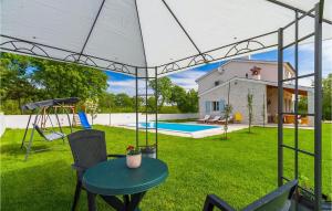 un patio trasero con una mesa y un columpio y una casa en Villa Azura, en Pula