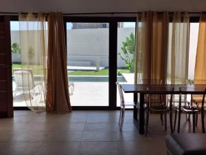 a dining room with a table and a view of a patio at villa eclore 2 in Sali Tapé
