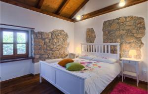 a bedroom with a white bed and a stone wall at Villa Casa Mira in Vižinada