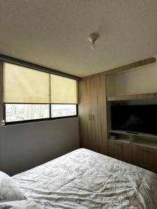 una camera da letto con un letto e una TV a schermo piatto di Departamento cerca del centro con vista al mar ad Antofagasta