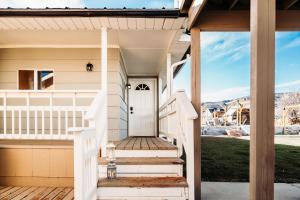 a white door on a house with stairs at Happy Trails BnB in Tropic