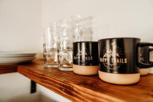 two coffee cups sitting on a wooden shelf with glasses at Happy Trails BnB in Tropic +59 photos