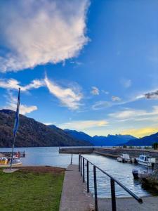 a dock on a lake with boats in the water at Monoambiente en la Montaña - De Alojamientos Lago Puelo in Lago Puelo