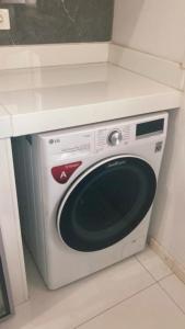 a white dishwasher in a kitchen under a counter at Lindo studio no Residencial Quisisana in Poços de Caldas