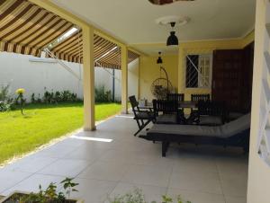 a patio with a table and chairs under a pergola at Charmante maison Riviera Golf Jardins in Abidjan