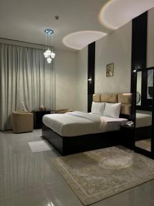 a bedroom with a large bed and a living room at Al Zahra Hotel Apartments Ras Al Khaimah in Ras al Khaimah