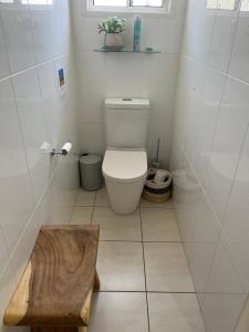 a bathroom with a toilet and a wooden stool at Wallawa on Hilltop in Ellesmere +21 photos