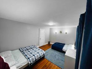 a bedroom with two beds and a blue rug at Home besides Niagara Falls, NY in Niagara Falls