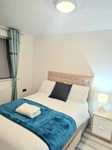 a bedroom with a bed with a blue blanket on it at Riverdale Cosy home for business,contractors,retreat in Ollerton