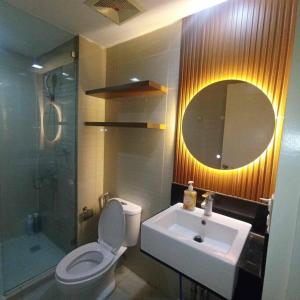 une salle de bain avec toilettes, lavabo et miroir dans l'établissement Venice Luxury Residences Studio McKinley Hill, à Manille