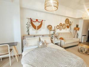 une chambre avec un grand lit et un canapé dans l'établissement Venice Luxury Residences Studio McKinley Hill, à Manille