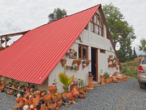 an orange roofed house with potted plants in front of it at Chalet El Edén in Ráquira