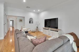 a living room with a couch and a flat screen tv at The Macleay - Poolside Entertainer, Pets Allowed in Wagga Wagga +19 photos