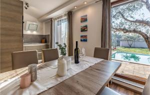 jadalnia ze stołem i dużym oknem w obiekcie 2 Bedroom Gorgeous Home In Pula w Puli +37 zdjęć