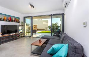 a living room with a couch and a tv at 2 Bedroom Stunning Apartment In Omisalj in Omišalj