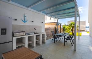 a kitchen with a table and chairs on a patio at 2 Bedroom Stunning Apartment In Omisalj in Omišalj