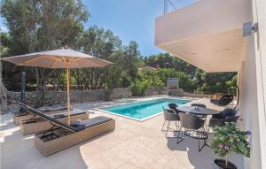 a patio with a table and an umbrella and a pool at 3 Bedroom Nice Home In Prizba in Prizba