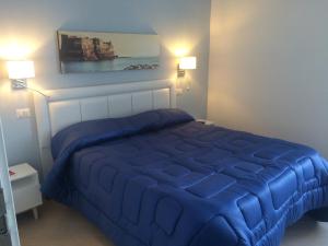 ナポリにあるBase Napoli Mergellinaのベッドルーム(2つのランプ付)の青いベッド1台