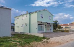 zielony i biały budynek z parkingiem w obiekcie 1 Bedroom Amazing Apartment In Biograd w Biogradzie na Moru