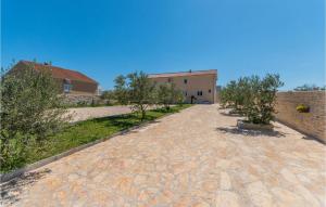 a brick road with trees and a building in the background at 7 Bedroom Awesome Home In Polaca in Polača +47 photos