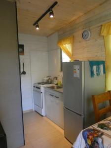 a kitchen with a stainless steel refrigerator and a sink at Cabaña en la naturaleza Futrono in Ranco
