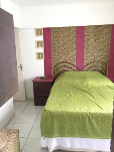 a bedroom with a green bed and a purple wall at Apartamento Barra Velha in Barra Velha