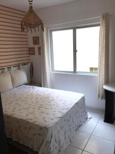 a bedroom with a large bed with a window at Apartamento Barra Velha in Barra Velha