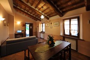 ein Wohnzimmer mit einem Tisch und einem Sofa in der Unterkunft Agriturismo Bagnaia in San Quirico dʼOrcia