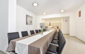 a long dining room table with black chairs and a white wall at Ten-Bedroom Holiday Home In Duce in Tice