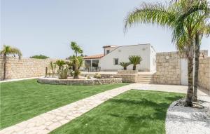 un giardino con una palma e una casa di Awesome Home In Pachino With Kitchen a Pachino