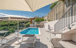 a patio with a pool and chairs and an umbrella at Holiday Home Plominska Ii in Rabac
