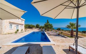 a swimming pool with an umbrella and lounge chairs and a swimming pool at Villa Toma in Škunca