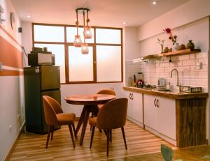 a kitchen with a table and chairs and a refrigerator at Departamento Cumbe Mayo in Cajamarca