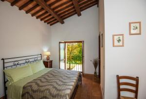 a bedroom with a bed and a sliding glass door at Agriturismo Olmo Bello in Capodimonte