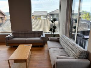 a living room with two couches and a coffee table at Beach enzi ビーチ エンジ in Sanuki