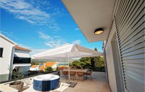 un patio con un tavolo e un ombrellone su un balcone di Villa Mondeo a Rogoznica (Rogosnizza)