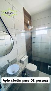 a bathroom with a sink and a toilet and a mirror at Studio aconchegante para duas pessoas in Bombinhas +18 photos
