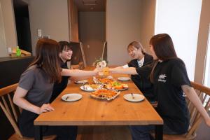 a group of people sitting around a table eating pizza at Beach enzi ビーチ エンジ in Sanuki +32 photos