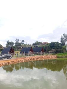 a group of huts next to a body of water at Lago Cristal Chalets in Los Santos +2 photos