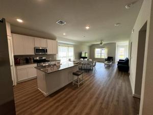 a large kitchen and living room with a table and chairs at Quite big home near Tesla & COTA in Del Valle