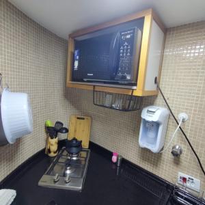 a kitchen with a stove and a tv on the wall at Aconchegante 4 Pessoas Hakka Eventos, Hospitais e Feirinha in Sao Paulo +34 photos